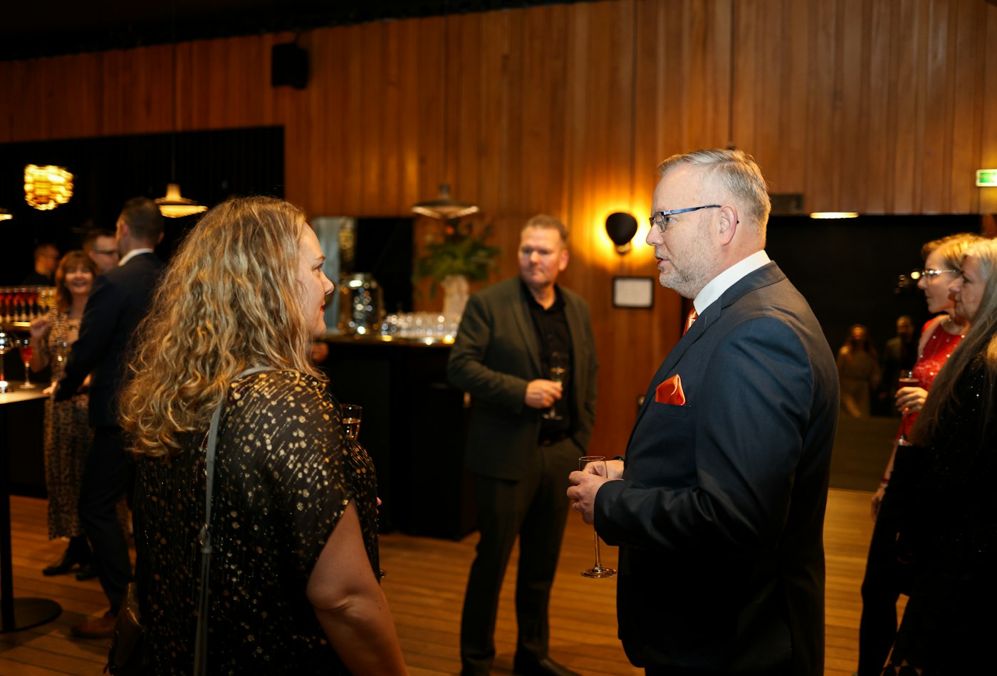 Chamber members mingling and talking at an evening business networking reception.