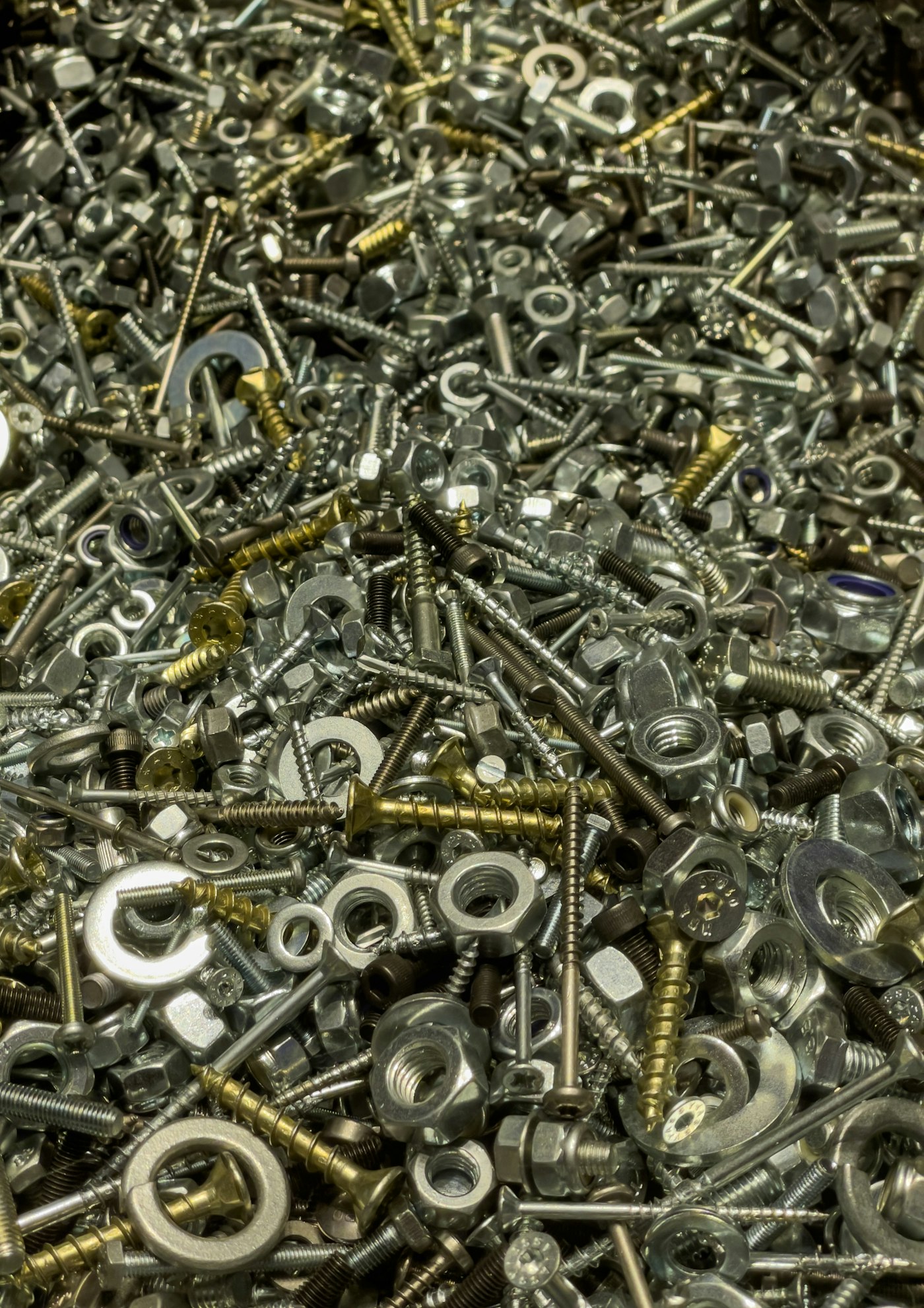 Close-up of assorted nuts, bolts and hardware, representing Prairie Crossing Hardware's stock.